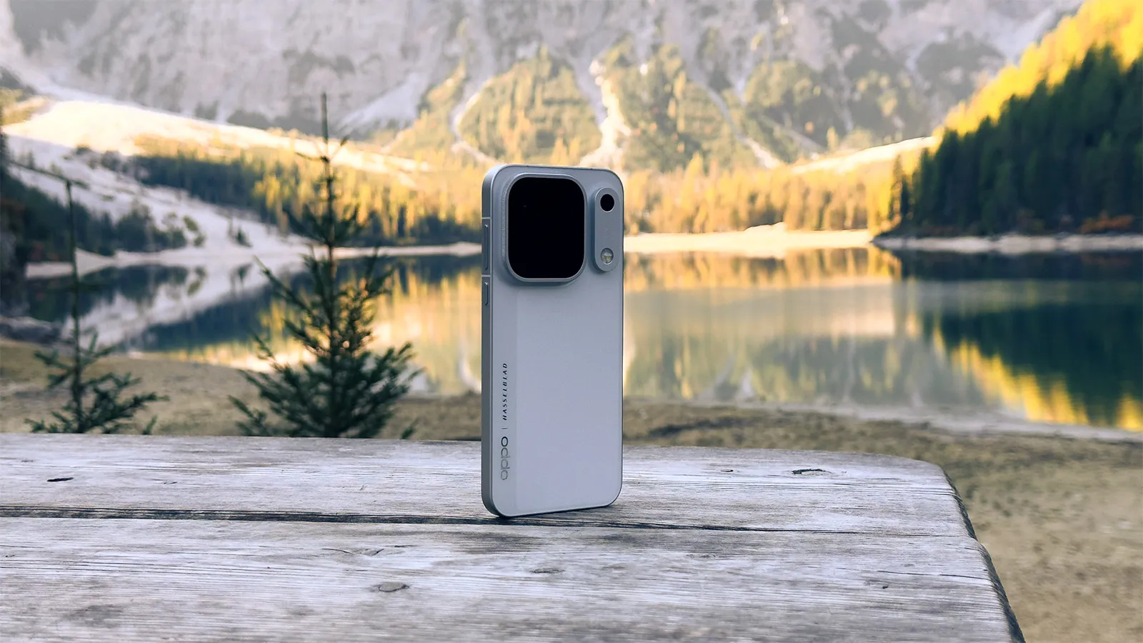 Dos d'un téléphone OPPO Find X10 Pro Max sur une table en bois avec un lac et des montagnes en arrière-plan.